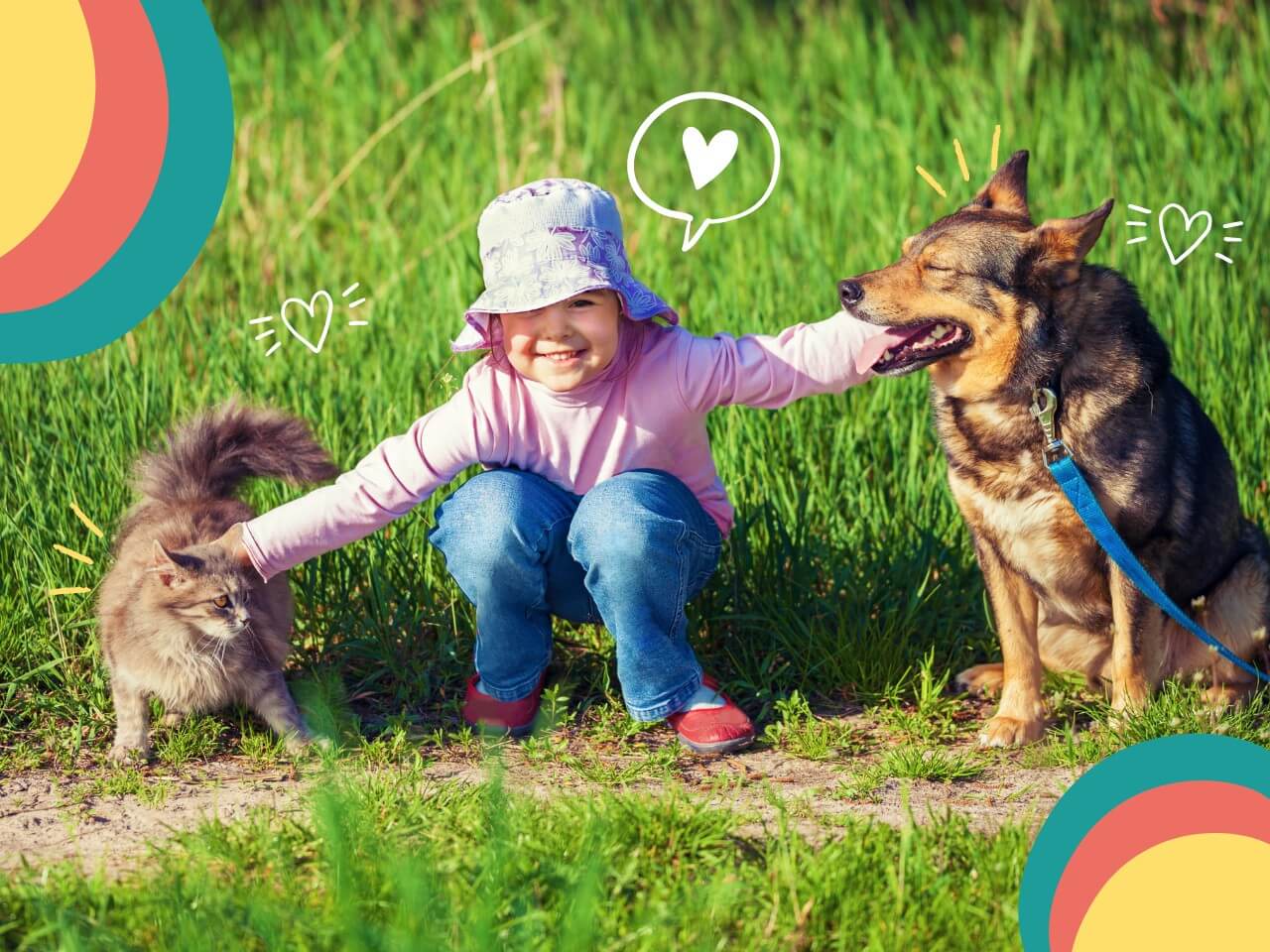Niña pequeña con sombrero sonriente acariciando simultáneamente a un gato gris y un perro café en jardín con pasto verde